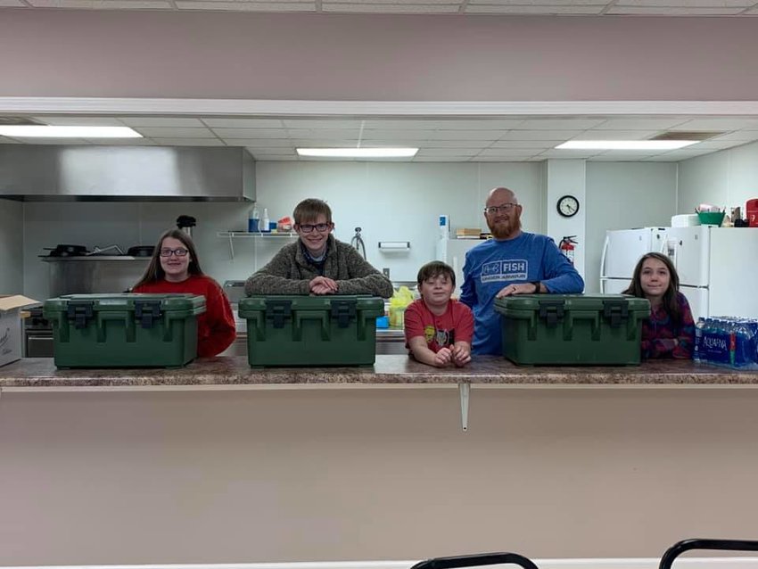 Ivie Savell, Eli Sharp, Evan Sharp, the Rev. Eric Sharp and Chloe Savell prepare to hand out food and water at New Bethel Baptist Church.